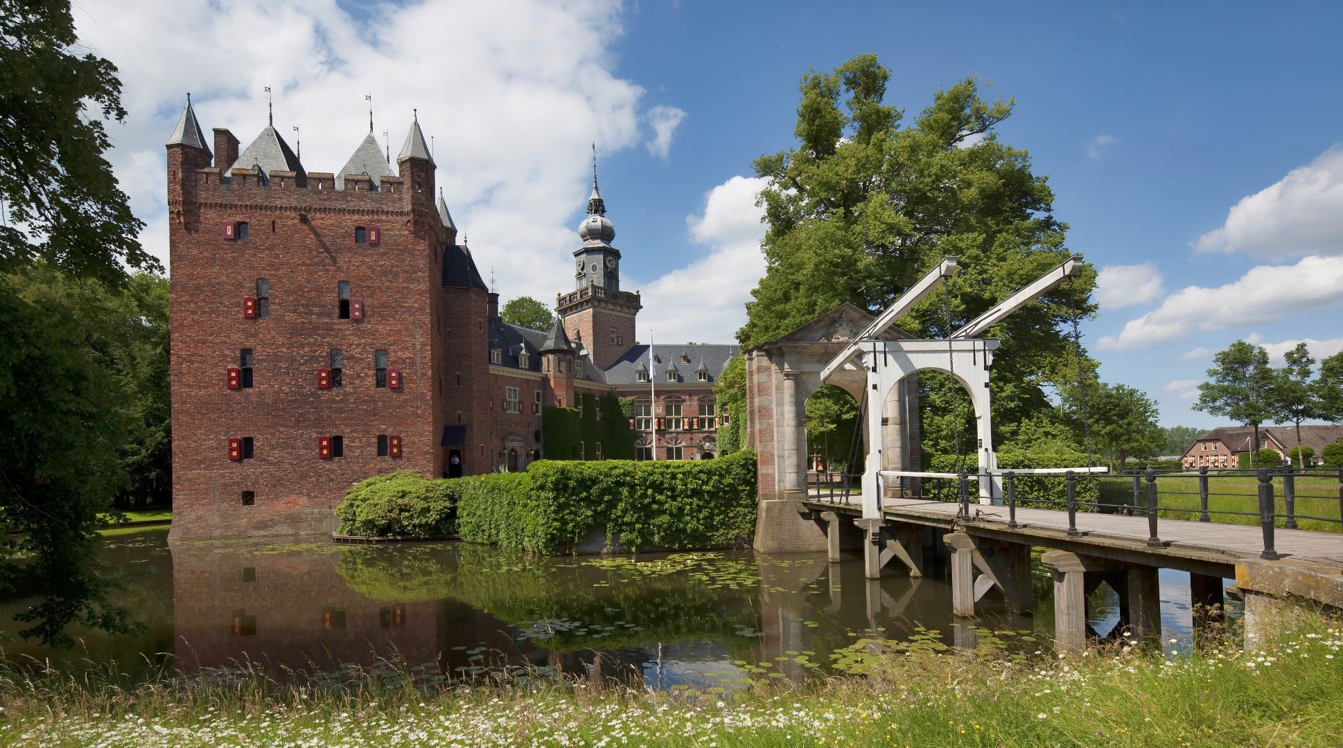 Kasteel met ophaalbrug omgeven door water en groen